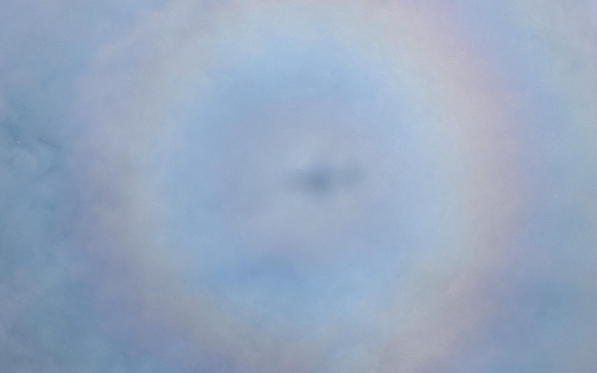 Pilot's halo - Shadow of our plane inside a full 360° rainbow in the clouds.